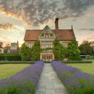 A flagstone path cuts through the garden lawns straight to the hotel's building, flanked by flowering lavender